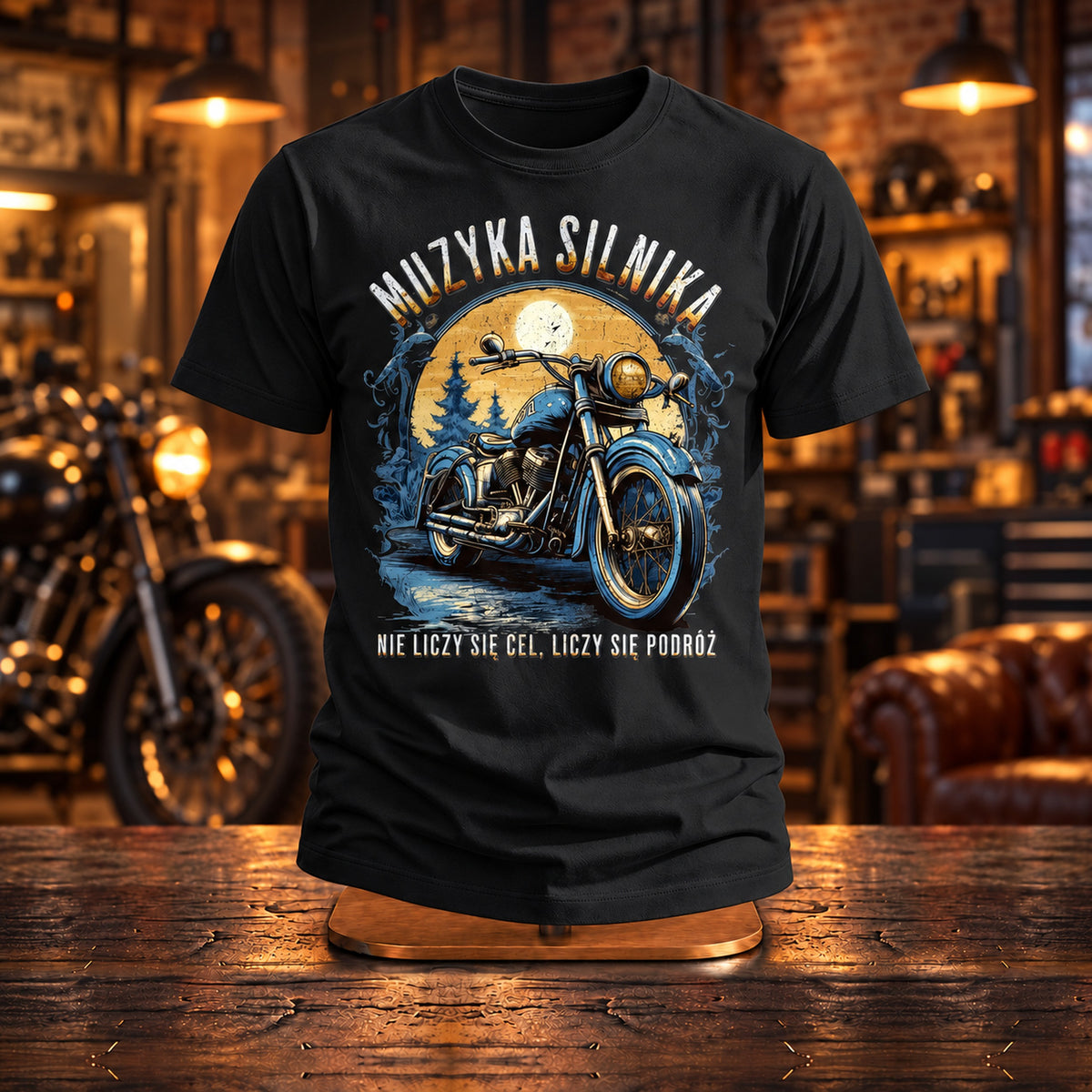 Czarna koszulka „Muzyka Silnika” z motocyklem na drewnianym stojaku w warsztacie motocyklowym