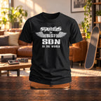 The Best Son In The World wings T-shirt in black on a wooden stand in a living room with a skateboard - gift for son from his parents