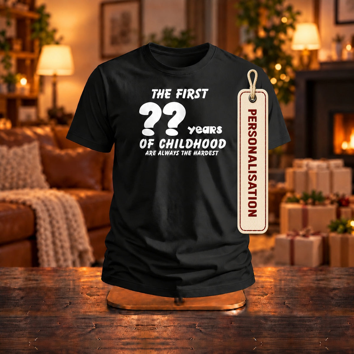 The First Years of Childhood personalised T-shirt in black with a PERSONALISATION tag on a wooden stand in a cosy living room - enter any age, birthday gift