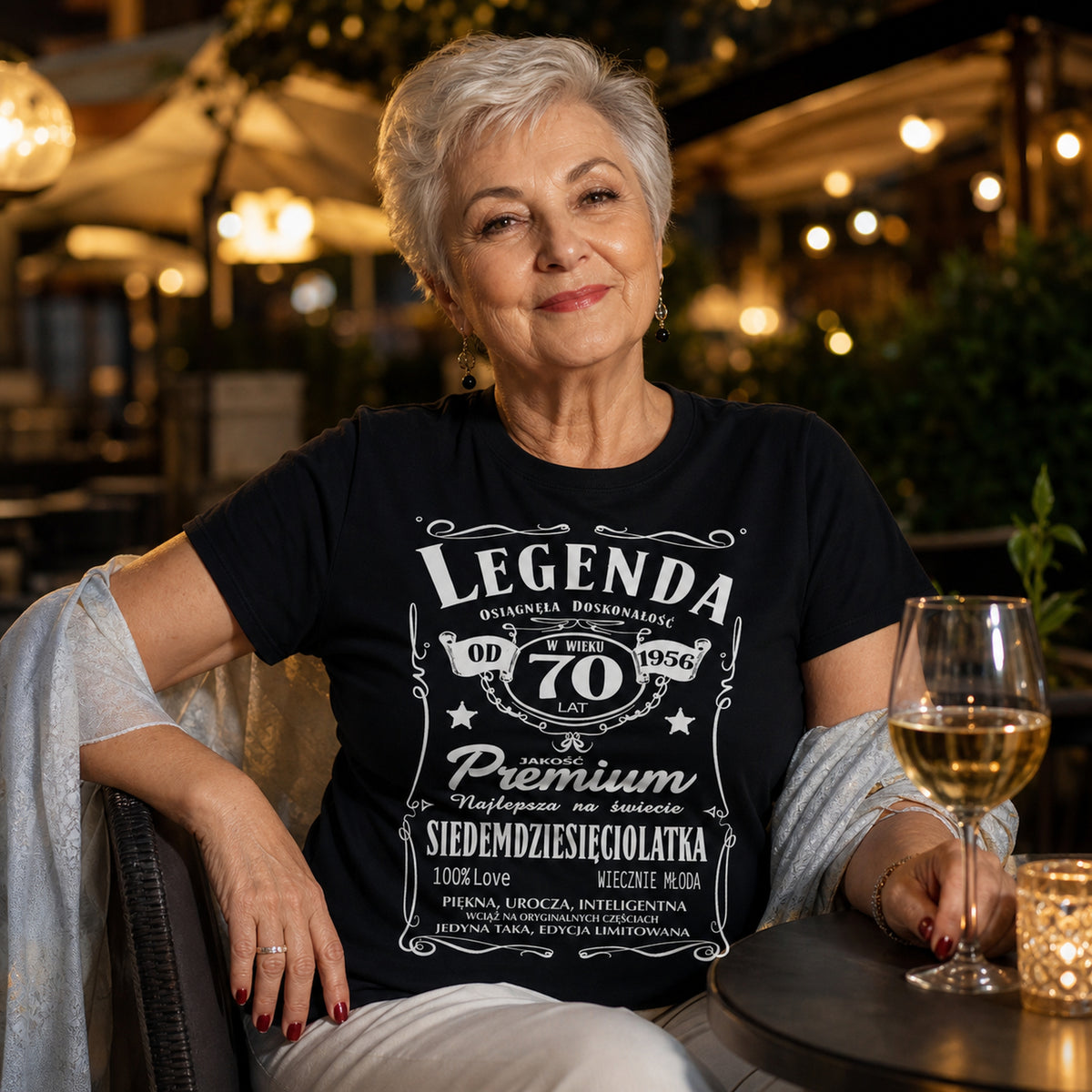 Koszulka Legenda od 1956 70 Lat Siedemdziesięciolatka w kolorze czarnym - kobieta z kieliszkiem wieczorem w restauracji, prezent na 70 urodziny dla kobiety