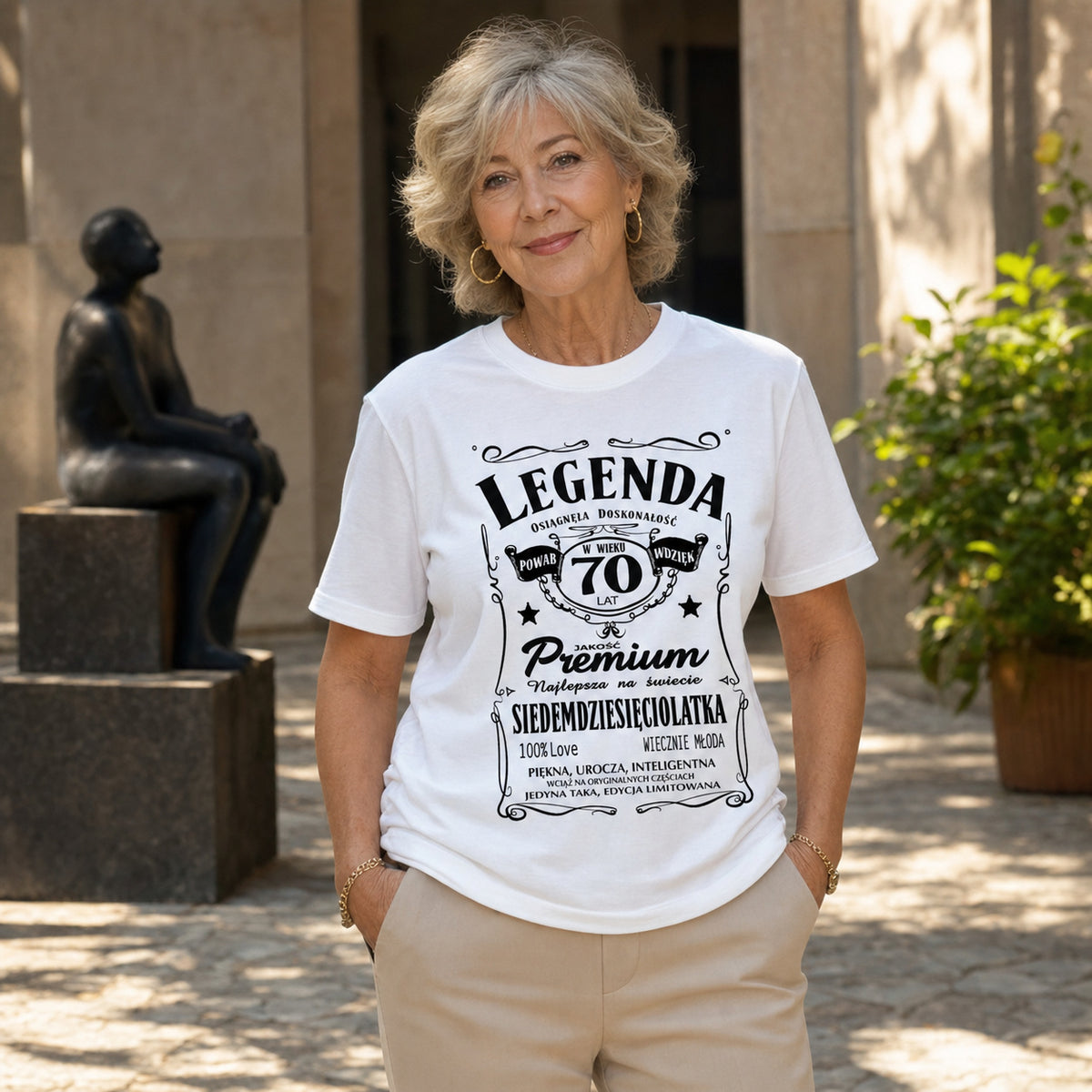 Koszulka Legenda 70 Lat Siedemdziesięciolatka w kolorze białym - kobieta na dziedzińcu z rzeźbą, prezent na 70 urodziny dla kobiety