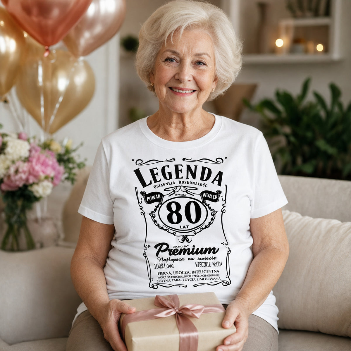 Koszulka Legenda 80 Lat Powab Wdzięk w kolorze białym - kobieta z prezentem w salonie z balonami, prezent na 80 urodziny