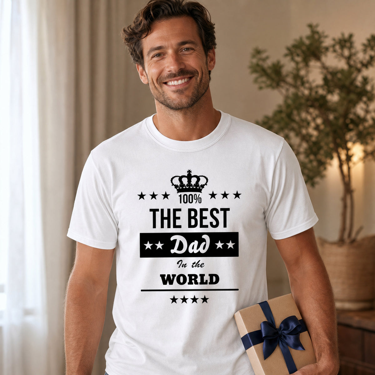 The Best Dad in the World t-shirt in white - dad holding a wrapped present at home, Father's Day gift