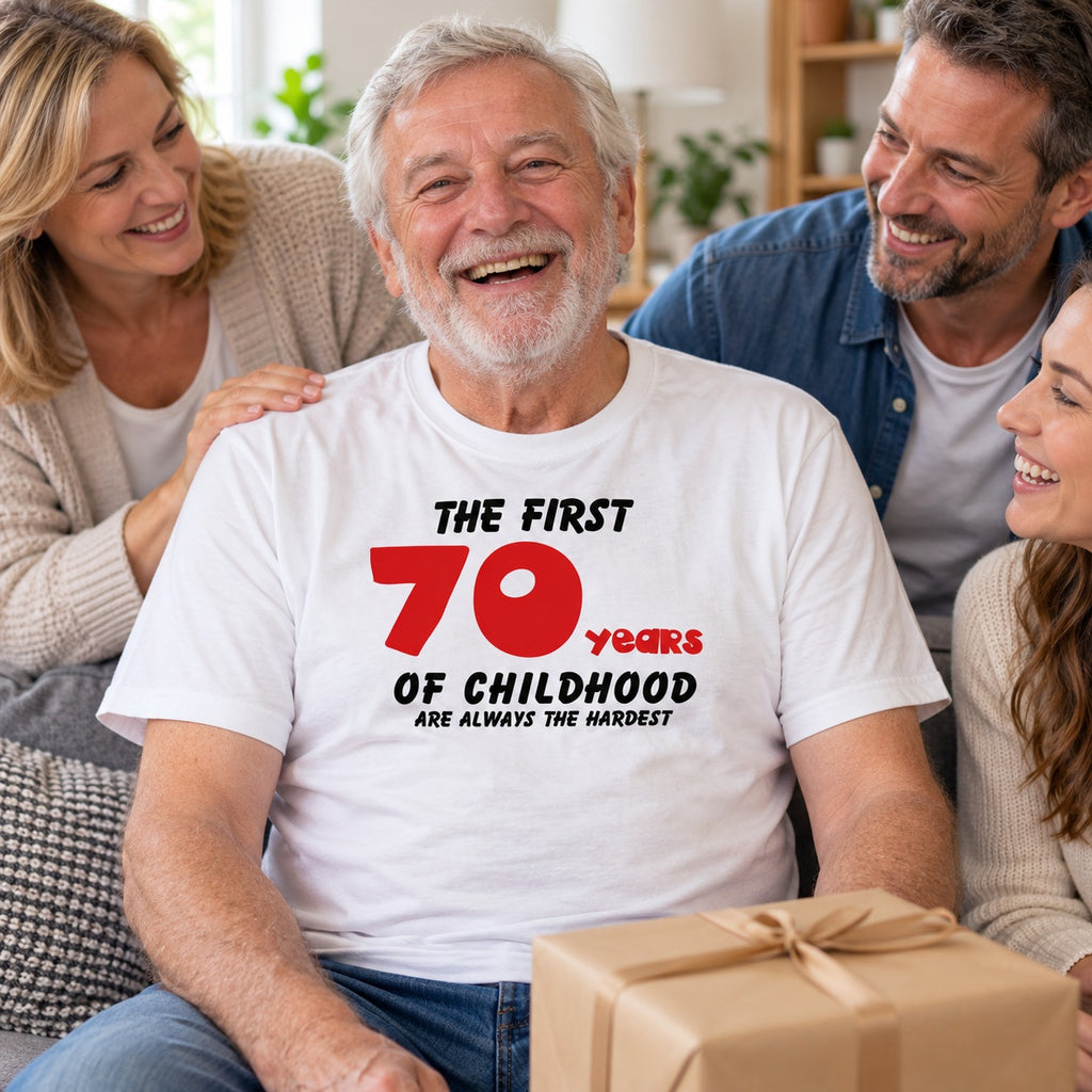 The First 70 Years of Childhood T-shirt in white with a red 70 - laughing grandad with a birthday present and his family, 70th birthday gift
